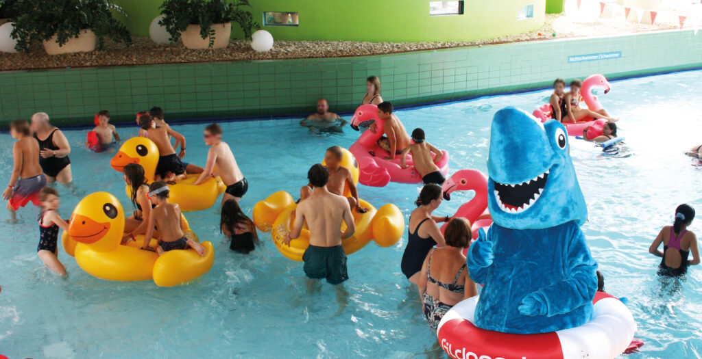 Menschen im Wasser mit Schwimmringen